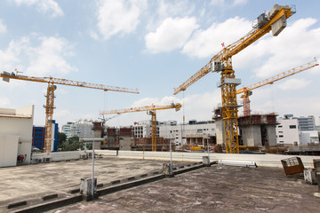 Fototapeta na wymiar Construction Cranes Against Blue Sky