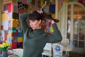 young beautiful woman pose on chair by window 