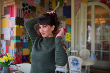 young beautiful woman pose on chair by window 