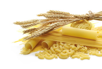 Various raw pasta types and wheat ears isolated on white background