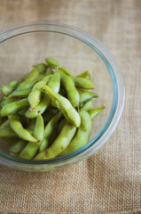 close up portrait of Japanese food edamame nibbles, boiled green soybeans 