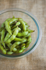 close up portrait of Japanese food edamame nibbles, boiled green soybeans 