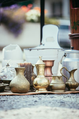 Obraz na płótnie Canvas Antique teapots, creamer and other utensils at a flea market. Old metal tableware at a garage sale.
