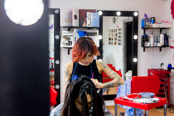 Professional hairdresser working with client in salon