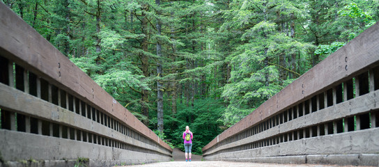 Female Hiker standing at end of bridge for perspective © James Kelley