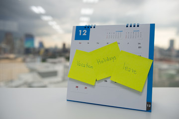 Vacation, holiday and leave on paper note stick on the calendar of December for year end holidays concept