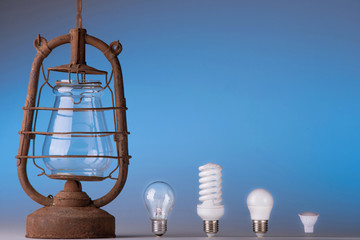 Old and modern light led bulbs on blue background
