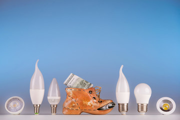 Led lamps and piggy bank standing on a blue background