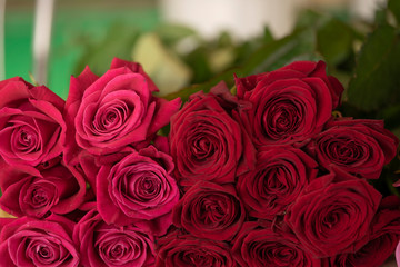 Close up view of claret roses bouquet. Red roses background. Top view.