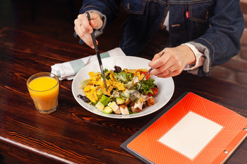 Girl fills salad with hands and cutlery