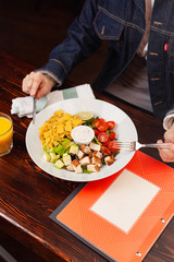 Girl fills salad with hands and cutlery