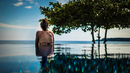 Rückenansicht Frau im Infinity Pool