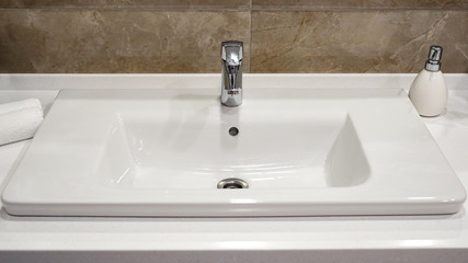 a silver tap in a white bathroom