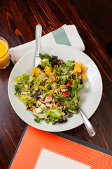 Girl fills salad with hands and cutlery
