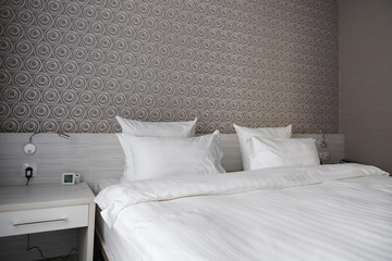 Bed, clean pillows and bed sheets in modern bedroom hotel