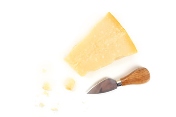 A piece of aged Parmesan cheese with crumbs, shot from the top on a white background with a cheese knife and a place for text