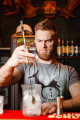 Brutal Barman cools the glass for the preparation of an alcoholic cocktail