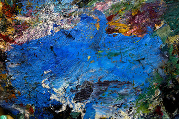 multi-colored strokes of oil paint on the artist's palette. background