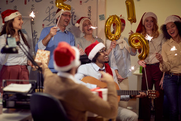 Successful colleagues in Santa caps having Christmas fun.