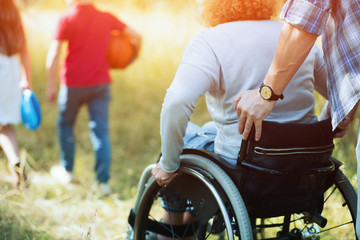 Close up look on woman's back in a wheelchair.