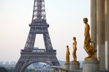 PARIS, FRANCE - JULY 7, 2018: Eiffel tower and golden staues, early morning in Paris, France - obrazy, fototapety, plakaty