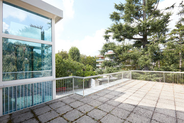 Large terrace in country house with big trees view and glass elevator