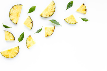Naklejka premium Slices pineapple with green leaves isolated on white background. Flat lay, top view