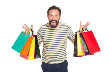 Waist up of delighted shopaholic holding paper shopping bags with purchases