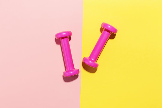 Dumbbells flat lay on pink and yellow