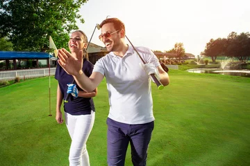 Papier Peint photo Golf Couple at the course playing golf and looking happy - Image