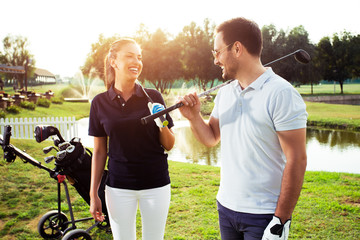 Couple at the course playing golf and looking happy - Image