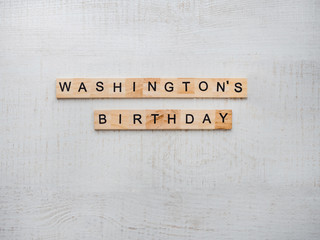Washington's Birthday, Presidents' Day. Beautiful greeting card. White, isolated background, close-up, top view, wooden surface. Congratulations for loved ones, relatives, friends and colleagues