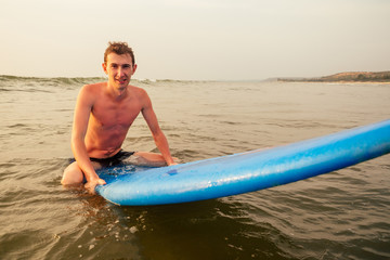 handsome young man enjoying a surf in water.male surfer in the ocean on surf board surfing at...
