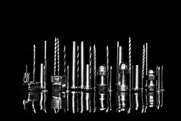 City on a black background with reflection from nuts, screws, bolts and nails