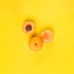 halves of pear on a yellow background. Cut into half-and-half apricot. Pastel colors, minimal trendy concept art. Top view. flat lay.
