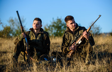 Hunting with friends hobby leisure. Rest for real men concept. Hunters gamekeepers relaxing. Discussing catch. Hunters with rifles relaxing in nature environment. Hunter friend enjoy leisure in field