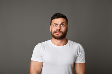 Fototapeta premium Muscular man grimacing guilty face at studio