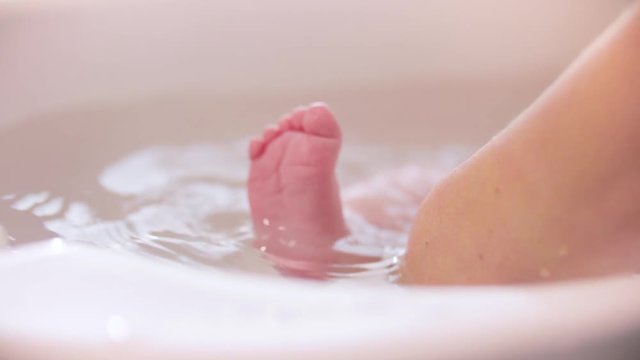 Cute baby in bath, close-up of feet.