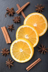 Fototapeta na wymiar Orange on Black Stone with Cinnamon and Star Anise
