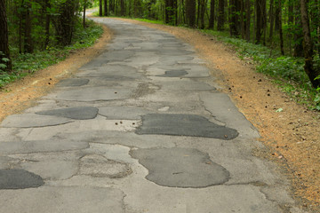 Old road repaired with asphalt patches