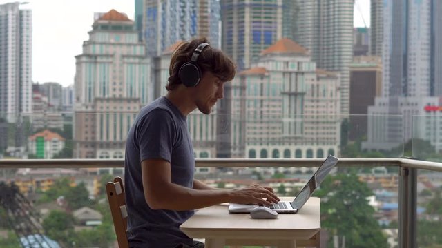 Remote techer has a conversation with a student through the internet at a balcony with a background of a city center full of skyscrapers. Student choosing e-learning program, easy effective self