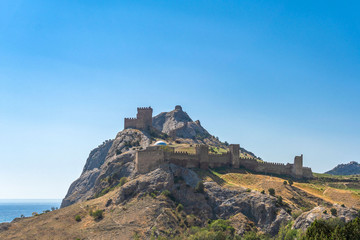 Fototapeta na wymiar View of the Genoese fortress in the city of Sudak, Crimea, against a blue sky.