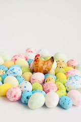 Easter figurine chicken and multicolored eggs on white background. soft focus