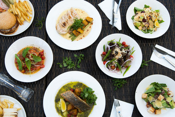 Mix Various Seafood, Spaghetti, club sandwich, burger, salad, hot spicy Foods on table over tropical ocean atmosphere, Top view camera dinner lunch together with friends family