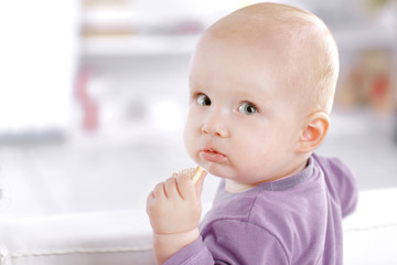 close up. pretty baby eats cookies and looks at the camera