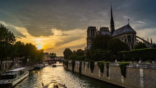 Timelapse of Paris at sunset, with boats passing in front of Notre-Dame-de-Paris cathedral on the Seine River