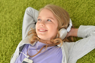 Cute little girl in headphones listening music