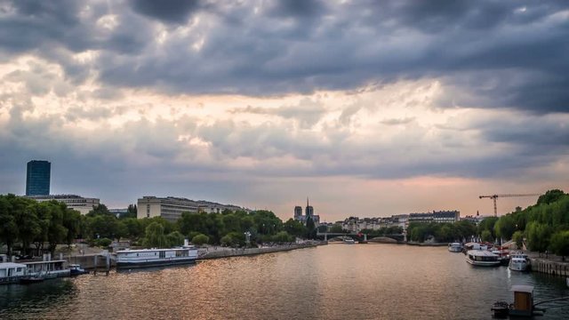 Timelapse of boats in Paris in front of Jussieu University, with a threatening cloudy and stormy sky, view from Austerlitz bridge