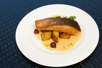 Deep Fried Salmon Seabass fish cut meat with fried potato chip, Fusion food stylish arrange on glass table along ocean mangrove tree Island, empty copy space for text logo Yummy