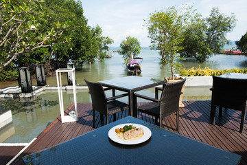 Baked brest chicken simple with recipe sauce dressing chip, Fusion food stylish arrange on glass table along ocean mangrove tree Island, empty copy space for text logo Yummy